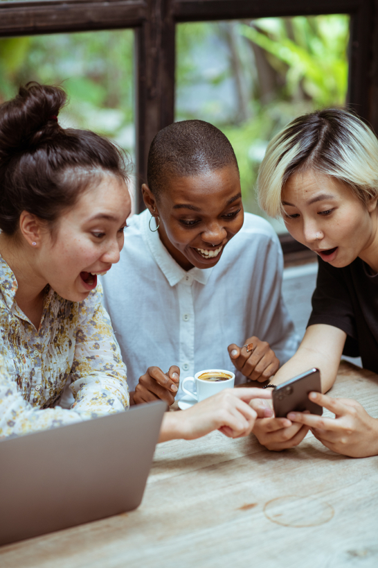 Three women are happy to find the best offer on social media and share their discovery